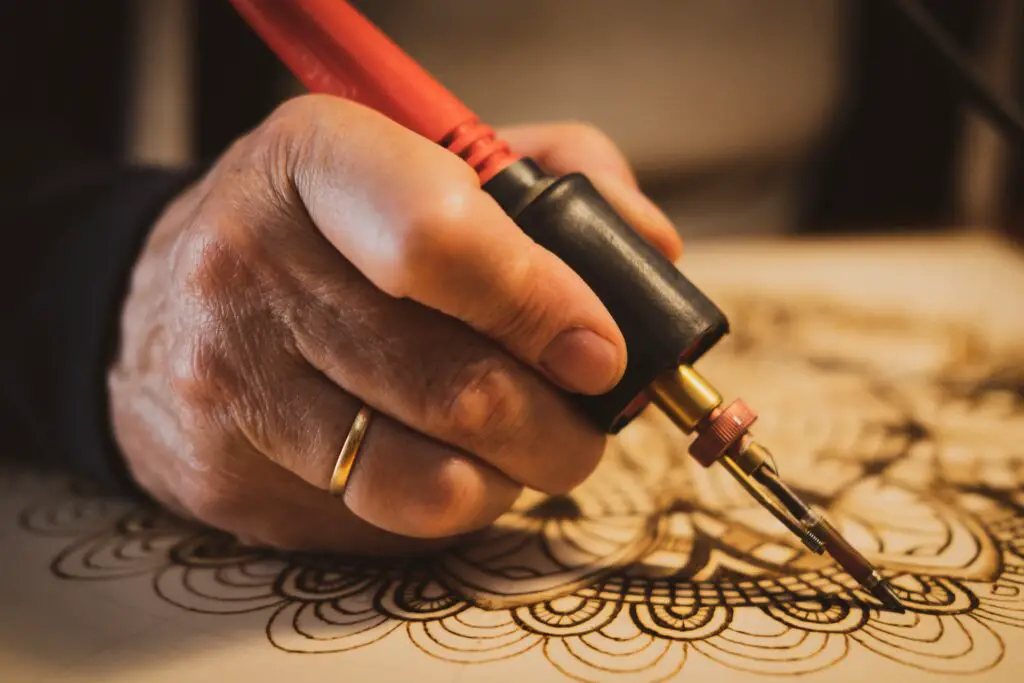 close up of man's hand doing pyrography