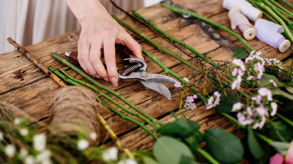 woman making bouquet with tools and flowers laid out on table