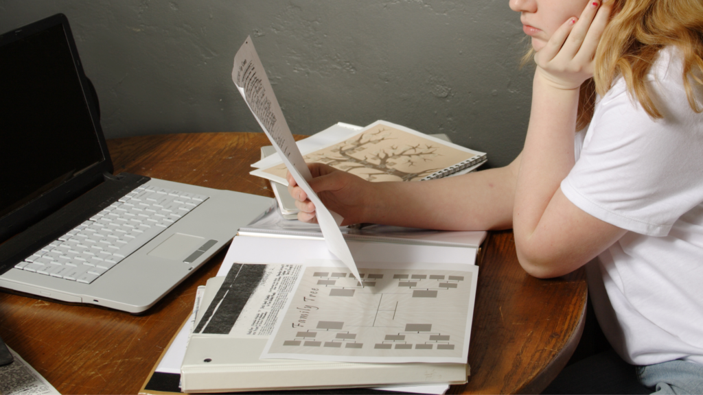 woman doing family tree / genealogy research sitting at table with computer