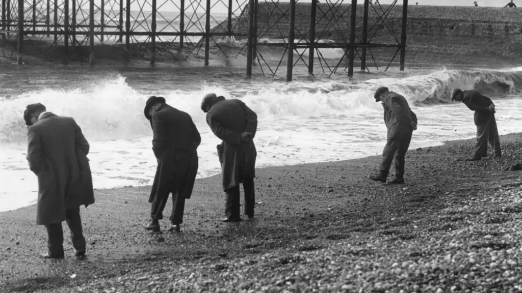 old timey photo of 5 men beach combing
