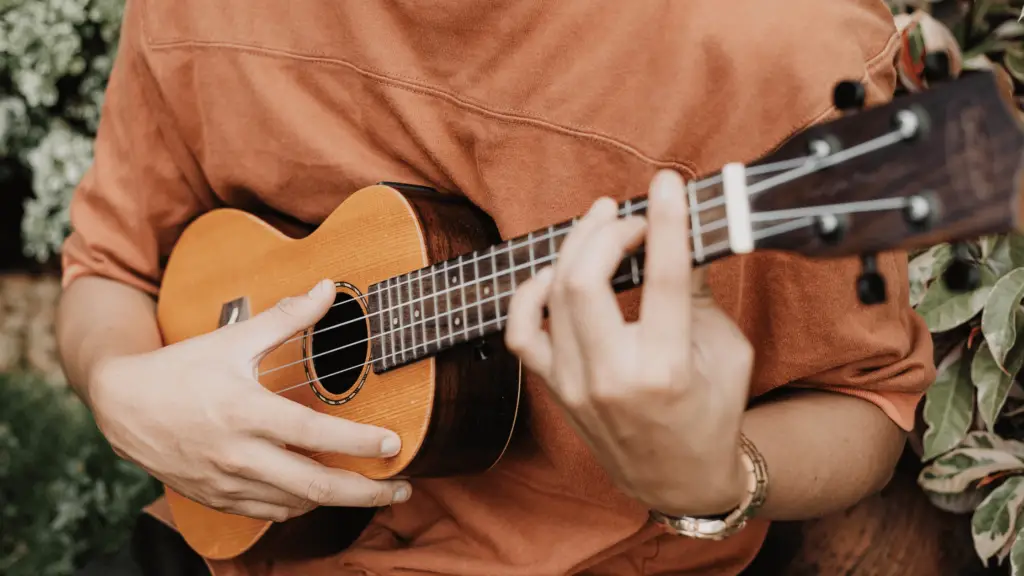 close up of man playing ukulele; relaxing hobby